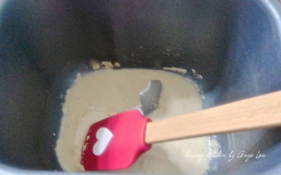 We are using a bread machine so place all ingredients in the pan. Start by adding lukewarm water into the pan. Add in the dry yeast. Then mix until the yeast is dissolved.