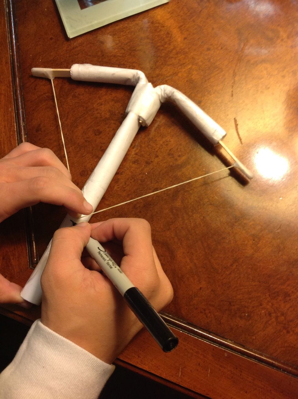 We got to see how far down the twine will pull  down so you pull it until it makes a square shape then mark it with a sharpie.