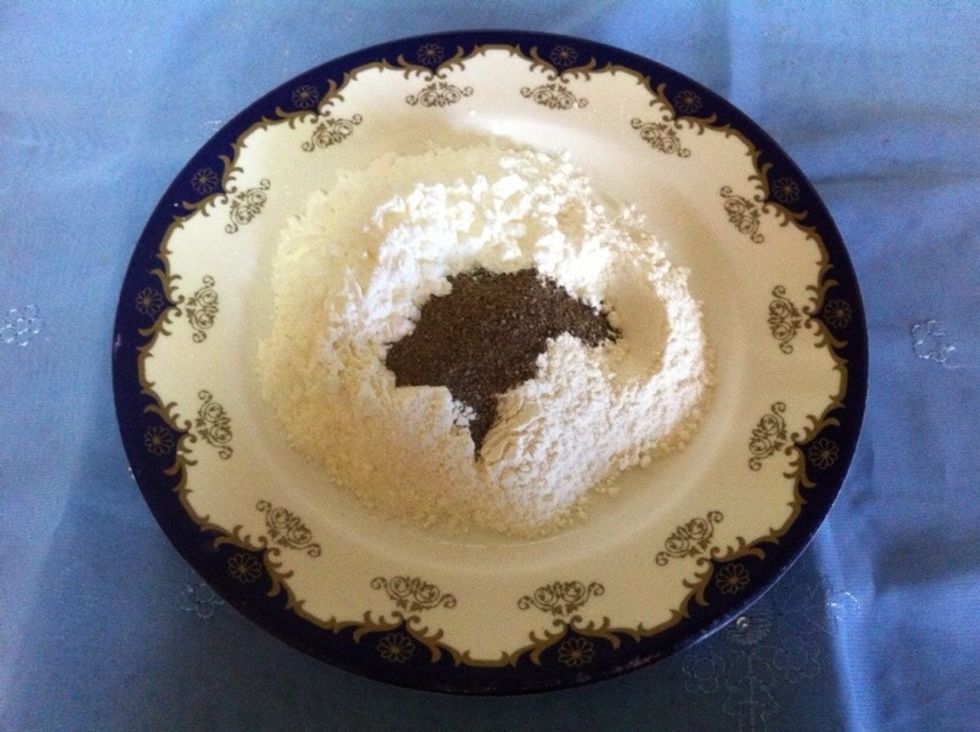 We need now to fry the fish but we must follow some steps before that :D ,, start by put amount of flour and black pepper into a plate ,, stir them