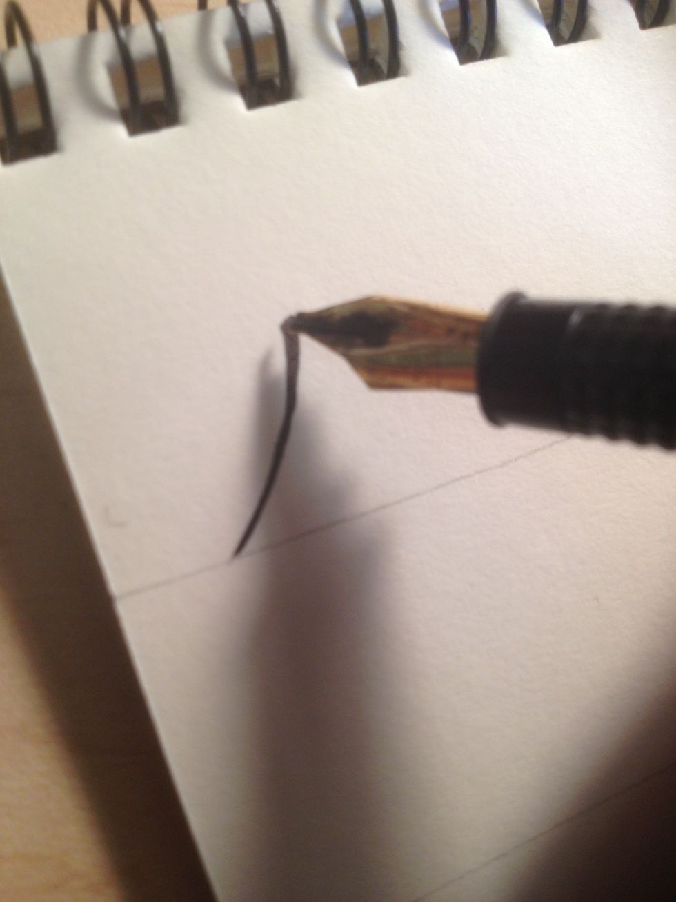 We're going to be learning the basic Majuscule (capital) alphabet. To begin A, start at the bottom line and make a slightly curved diagonal upward stroke.