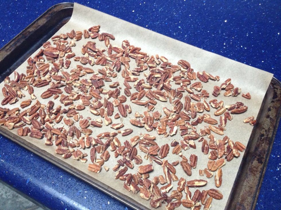 We're going to toast these pecans - they will taste 10 times better. Spread your pecans out evenly on a parchment lined jellyroll pan. Put them in the oven at 350\u00b0 for seven minutes.