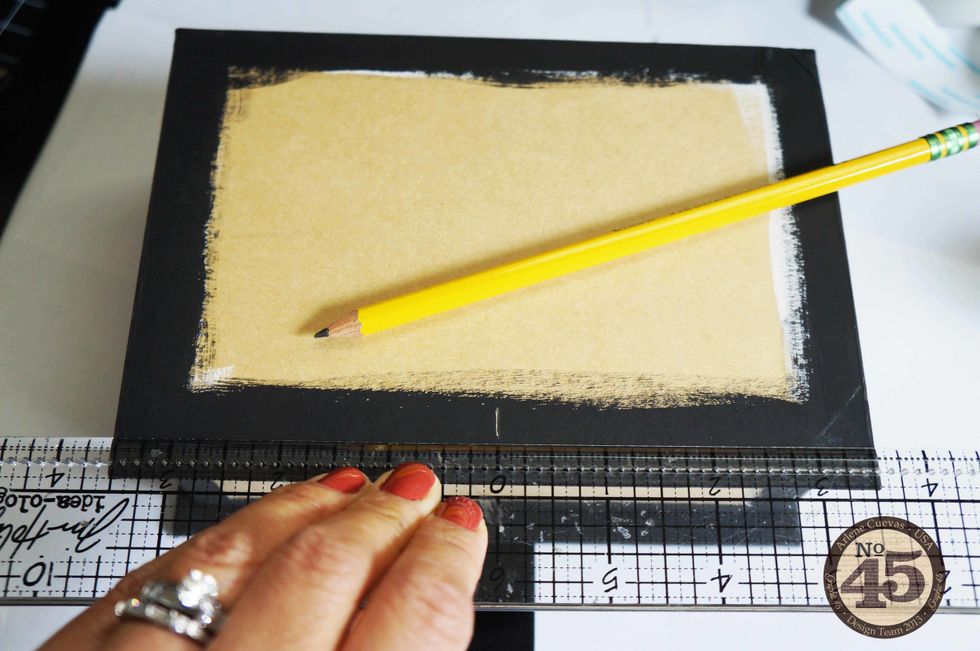 We will be adding ribbon to hold the box shut. Find the middle section of the box edge, right where the box opens up. Use your ruler to mark the center with a pencil.