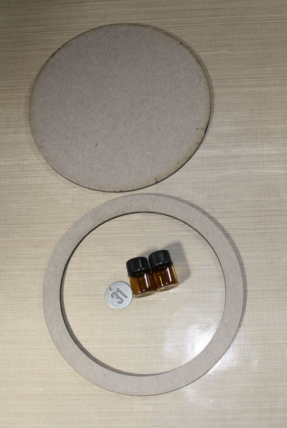 We will be using the large circle frame, two small sample bottles for essential oils, we will use the tops of the bottles for our steampunk goggles, and a metal 31 tag.