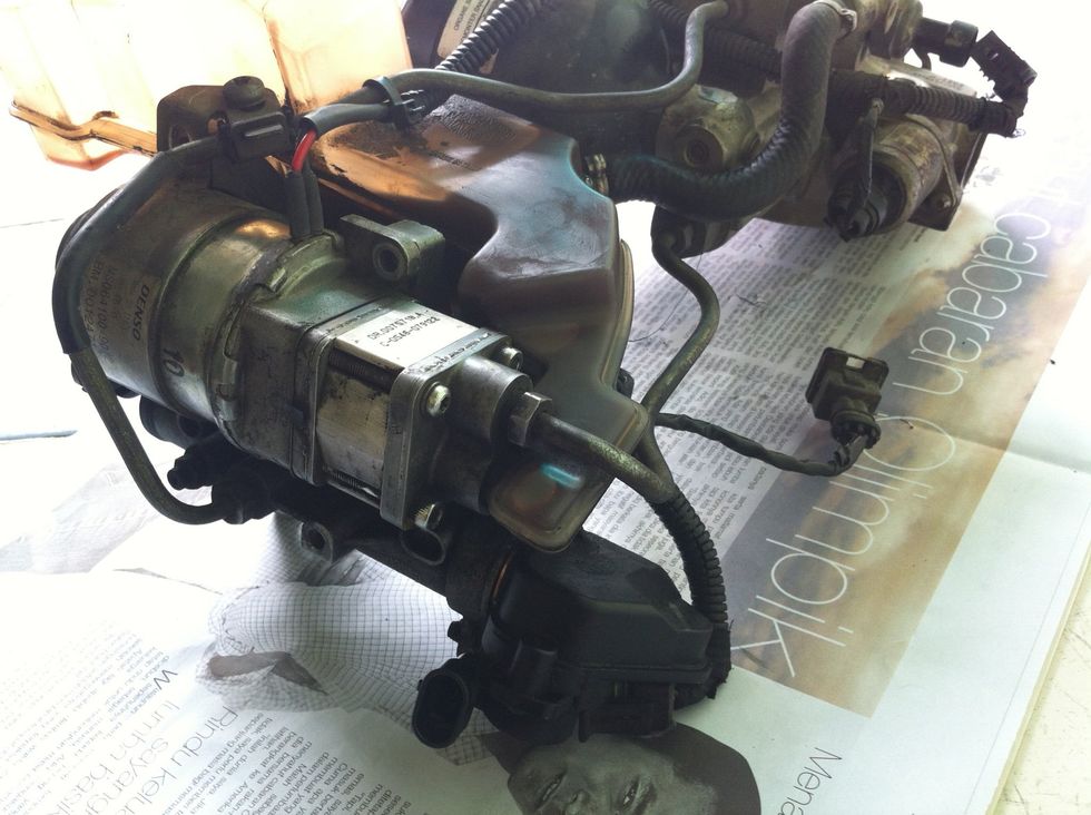 We will loosen up 1 nuts. Size 13. Pull out the pump and oil will come out. We can close it with a plastic bag and rubber band.