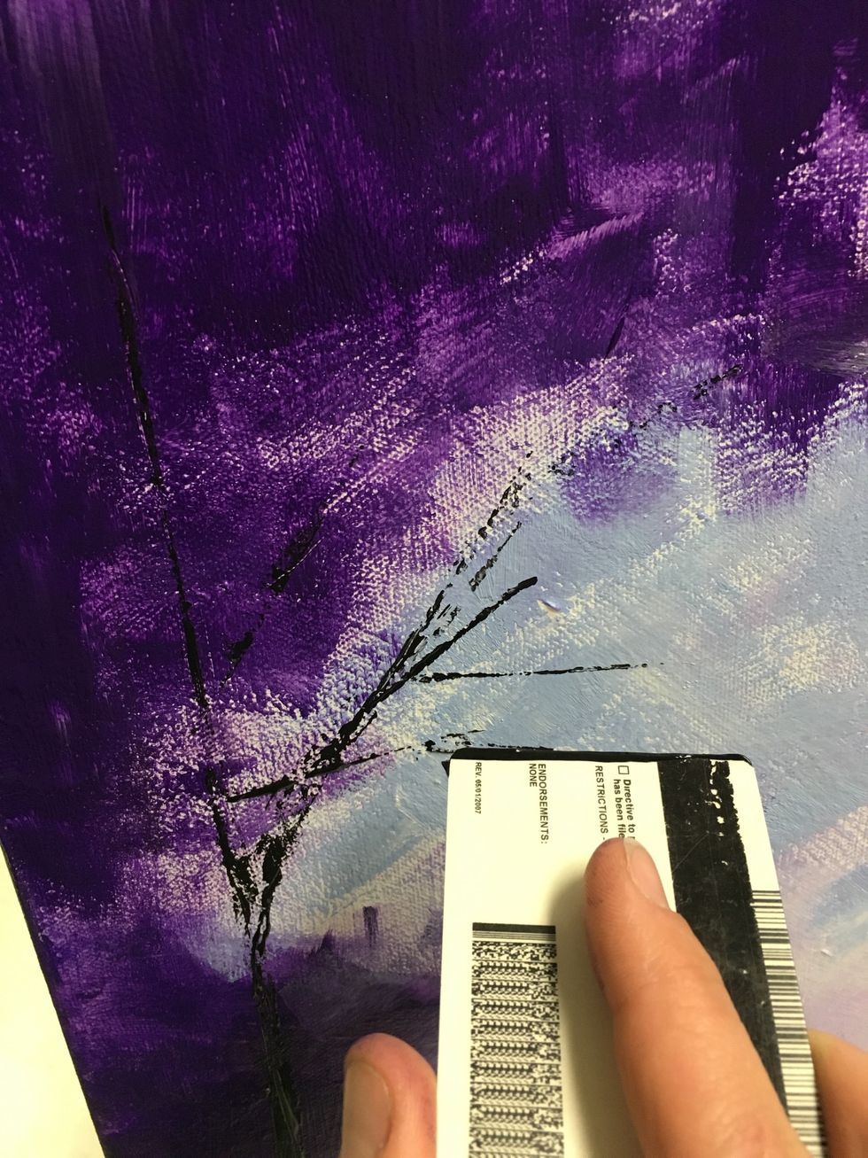 We will use a credit card to add a tree on the left side with black paint.