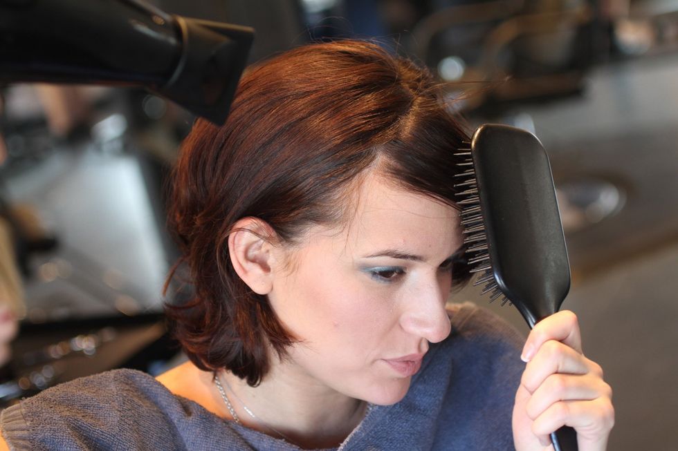 Wet bangs and brush from side to side as you blow dry them completely using a paddle or boar bristle brush. Add a styling product if you have a strong cowlick.