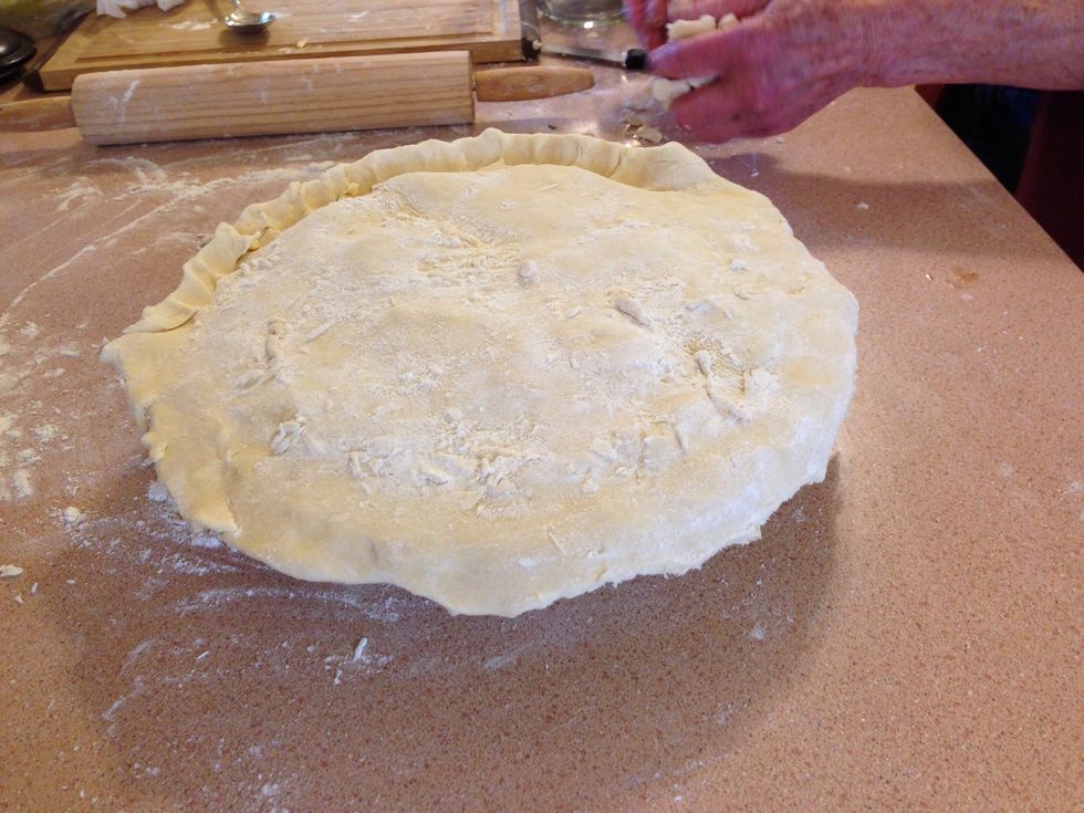 Wet the edges of the dough in the pan. Place top of dough onto the pie and press edges together to seal.