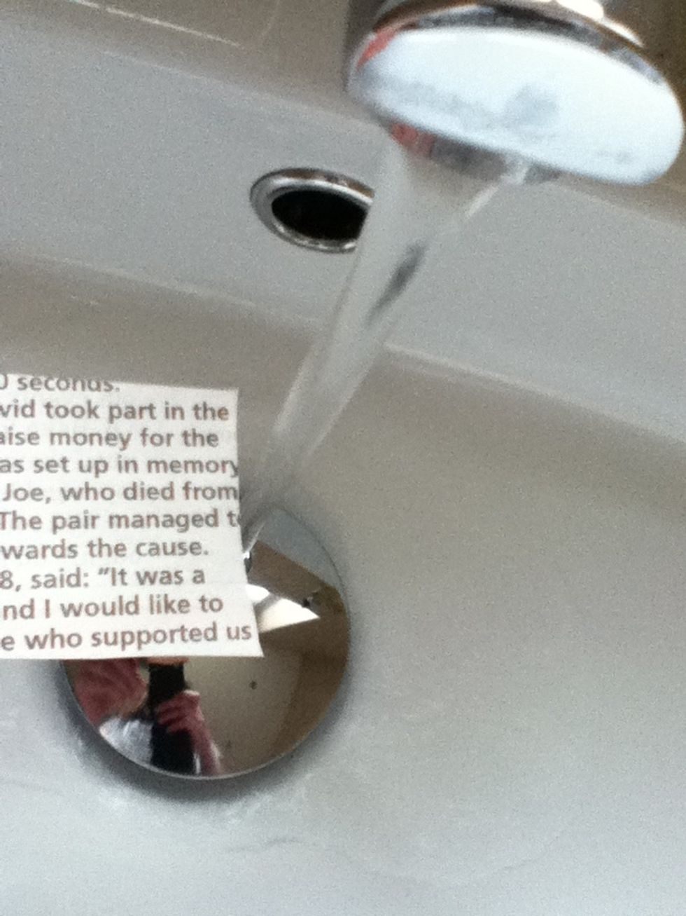 Wet the newspaper with water.