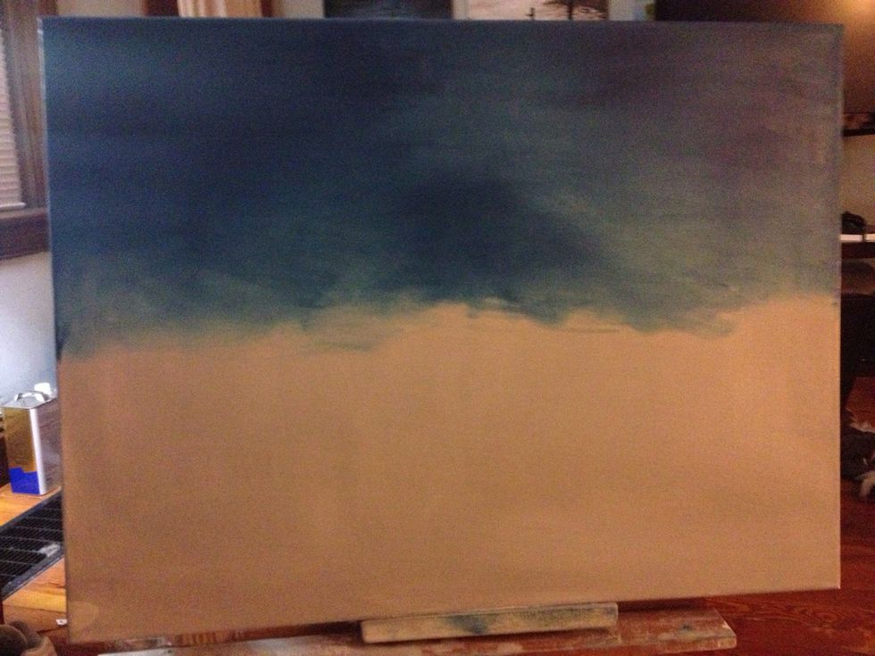 Wet your canvas with a liquid gray to start. Add Prussian Blue to your fingers, then to your canvas, starting at the top and working your way down.