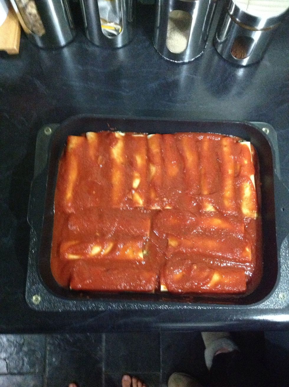 When all cannelloni is filled with the mixture pour remainder of sauce over them