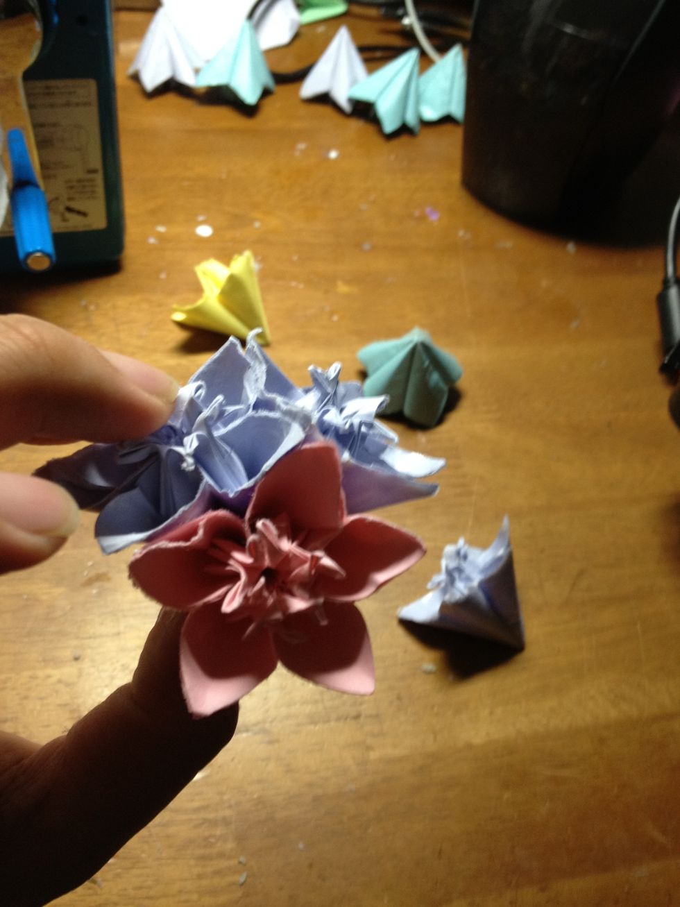 When all of your flowers are made, you can start putting it together. Glue the back of one of the petals and attached another petal from a different flower, like the pic above.