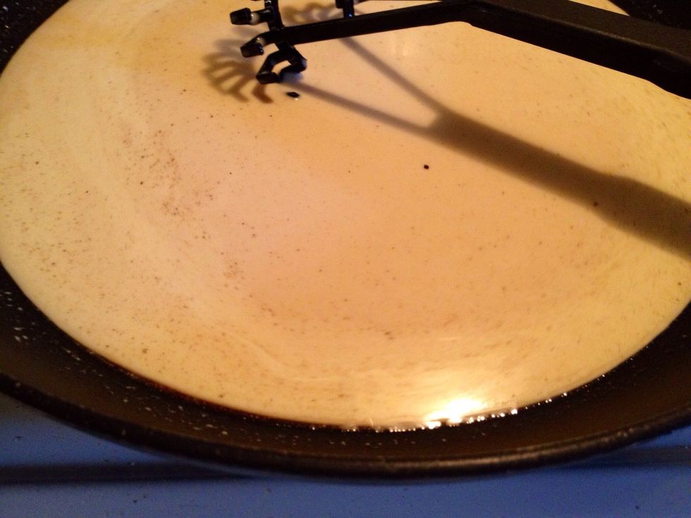 When all patties are cooked, pour some water into the skillet. Then pour it through a sieve into a pot or a frying pan. Add cream and the chopped onion.