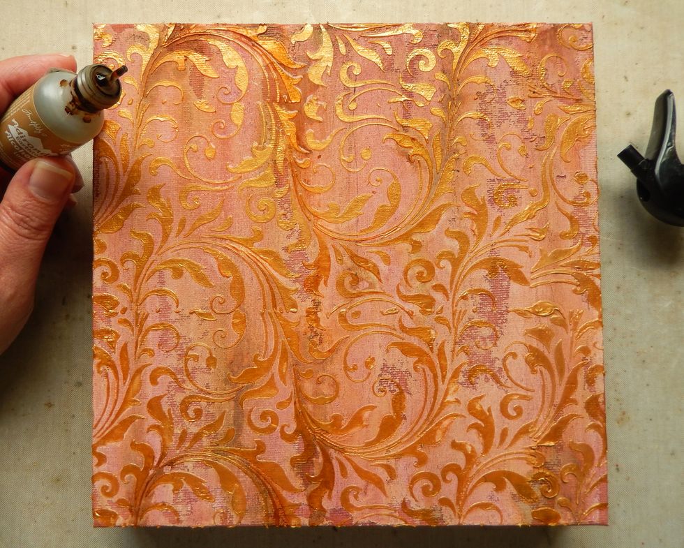 When all the embossing paste is dry apply small drops of Mushroom Alcohol Ink to the top and bottom edges of your canvas, spritzing with water and allowing the colour to run down the design.
