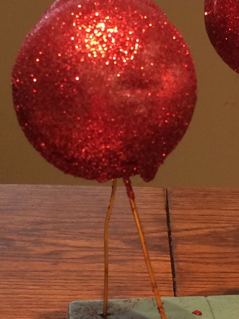 When applying glue, be careful to apply a thin coating. If you use too much it will drip like this. Don't panic... carefully press the drop back onto the ball and sprinkle more glitter onto the spot.