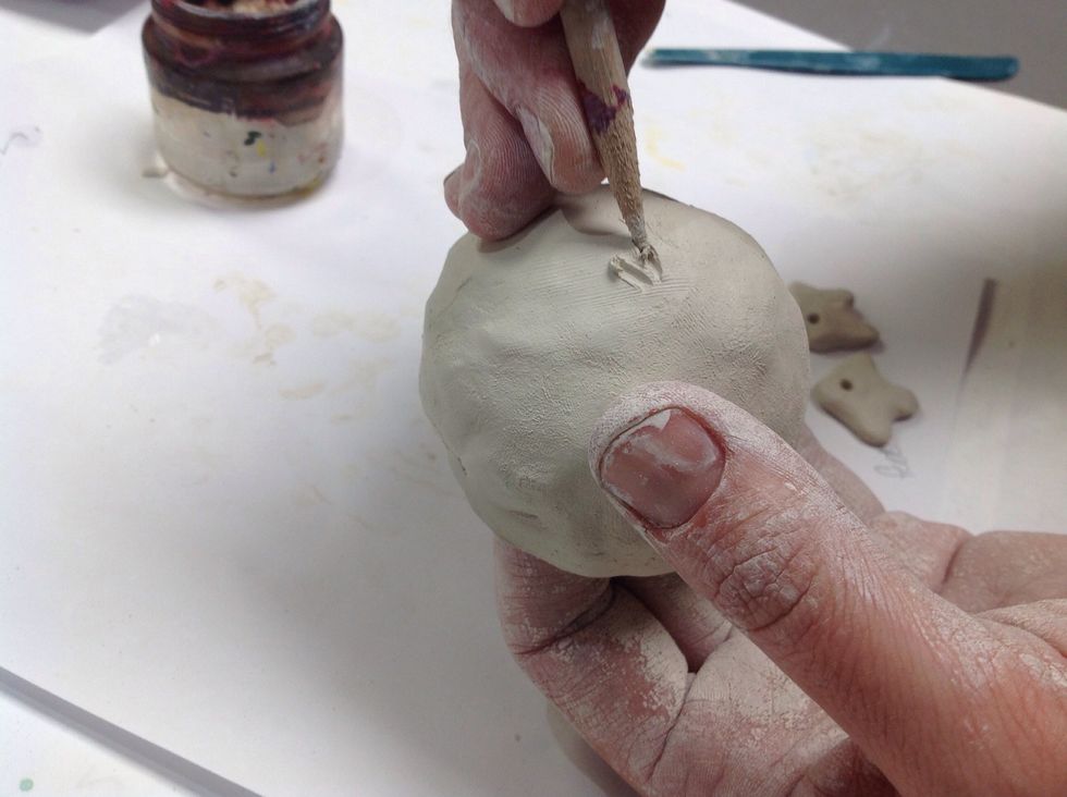 When attaching the pieces we must first slip and score so they stay adhered to the pinch-pot. You will need the toothpick and water.