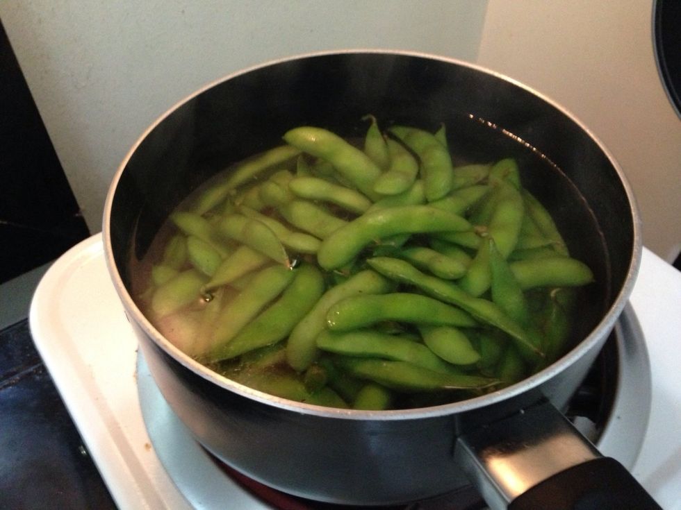 When boiling water boils, tun heat down and add the edamame.