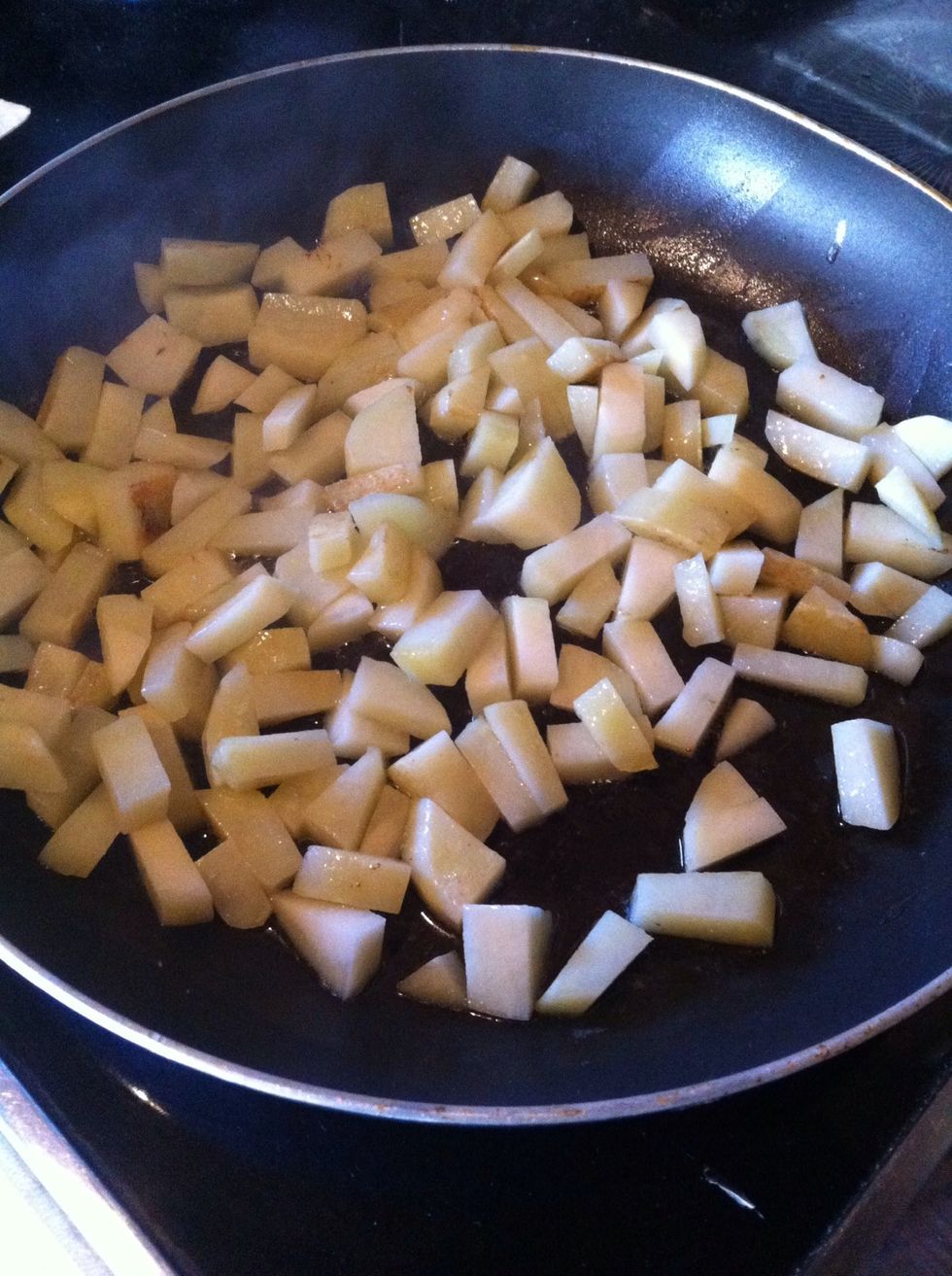 When butter has melted add potatoes...after they have cooked for a couple of minutes peel and dice a small onion and add to pan. Cook until onions are translucent and potatoes soft. Stir frequently