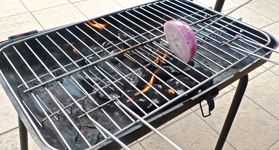 When charcoal has turned into red coal ashes, carefully put a CLEAN grilling grate over it. Then oiled the HOT grilling grate by dipping onion in cooking oil and brushing the grill grate with it.