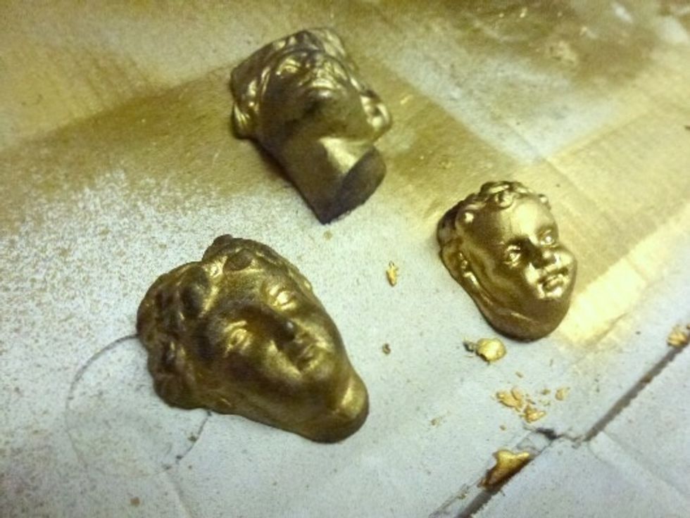 When crackle medium is dry apply a coat of spray gold foil paint to both the chest of drawers and cast. remove some of the gold paint from the cast to highlight the facial features and hair.