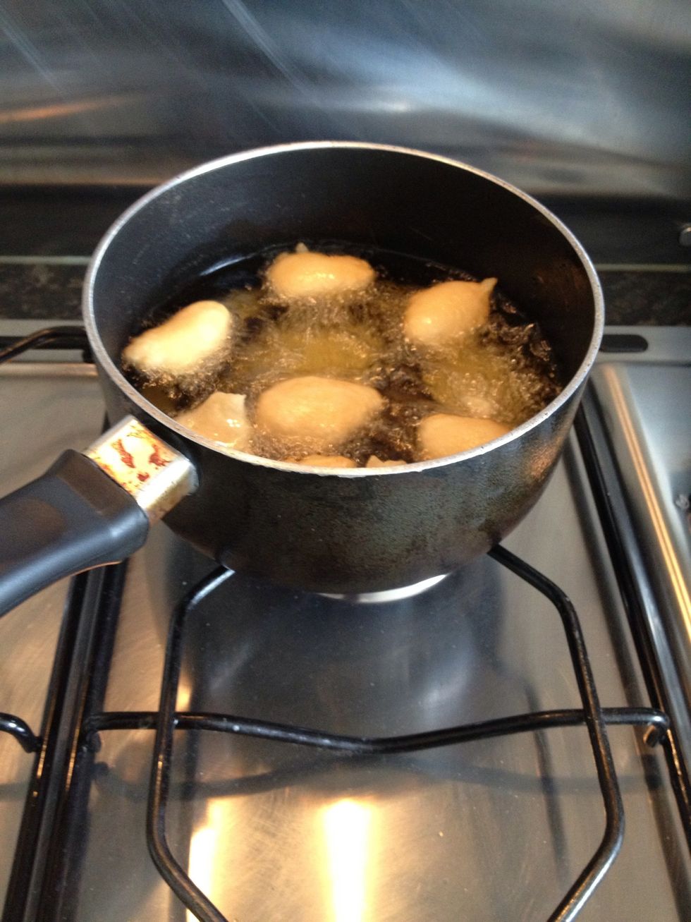 When d oil is hot enuf add d salt and mix properly just before spooning into d oil. U add d salt earlier and dt makes d beans watery. U kno d oil is hot enuf wen get bubbles when u spoon d mixture in.