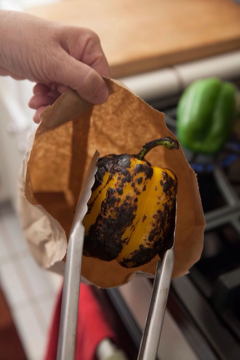 When each peppers skin is blackened, drop it into a brown paper bag and seal it tightly. Keep the pepper in the sealed paper bag for about 10 minutes.