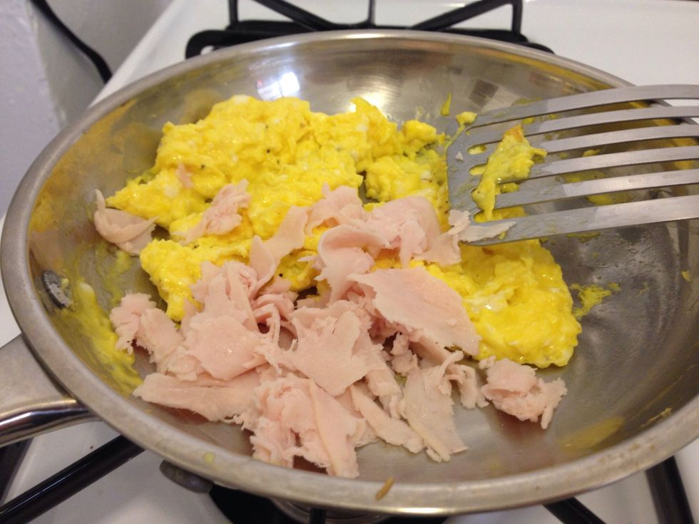 When eggs are almost done cooking, add lunch meat.