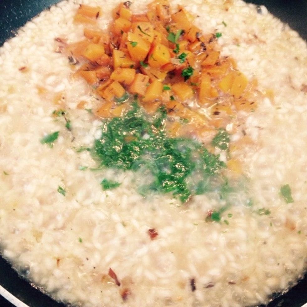 When half of the stock is evaporated add back the butternut squash and the chopped parsley.