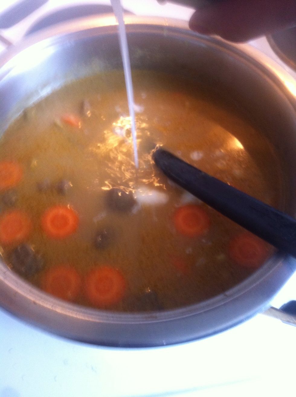 When it boils and the beef is cook enough. Add the carrots and pour the combination of milk and coconut milk. Let it all cook and the meat is tender.