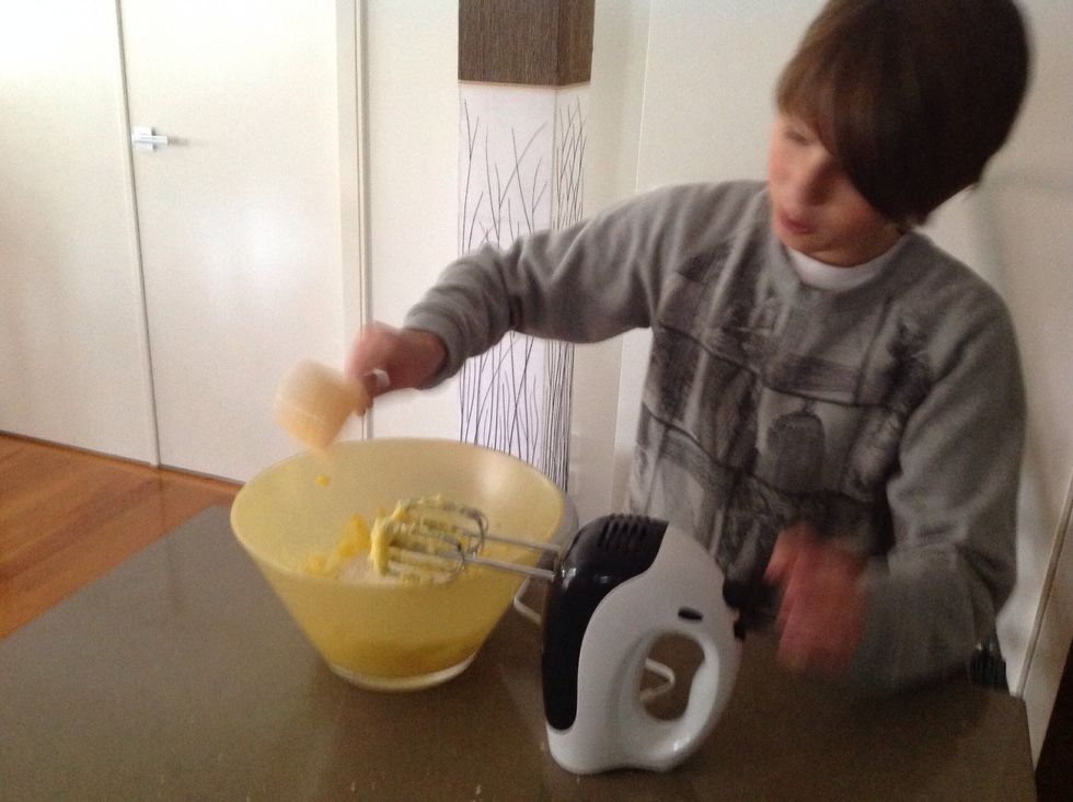 When it's light and creamy, add 1/2 teaspoon of vanilla essence and 1/2 teaspoon of grated lemon rind. Once that is combined, add 1 teaspoon of cream and the flours. Beat until smooth for piping.