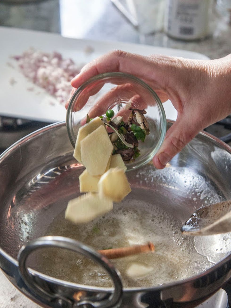 When it's nice a foamy toss in the cinnamon, bay leaves, shallot, cloves, cardamoms, serrano chilies, and ginger slices.