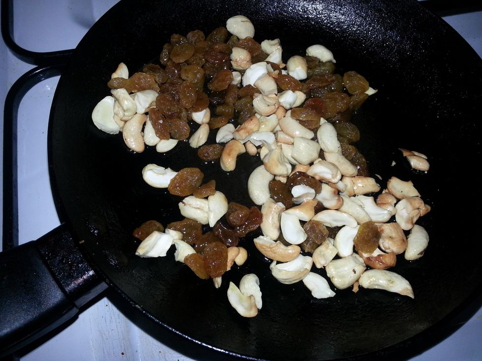When it starts to turn brown, add the cashew nuts and raisins.