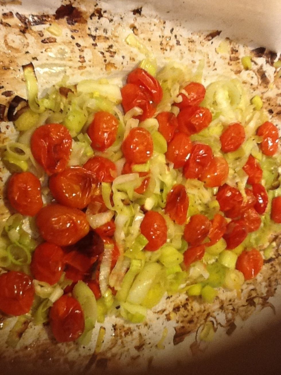 When leeks soften and tomatoes start to burst they're ready to come out of the oven. Turn the heat down to 325.