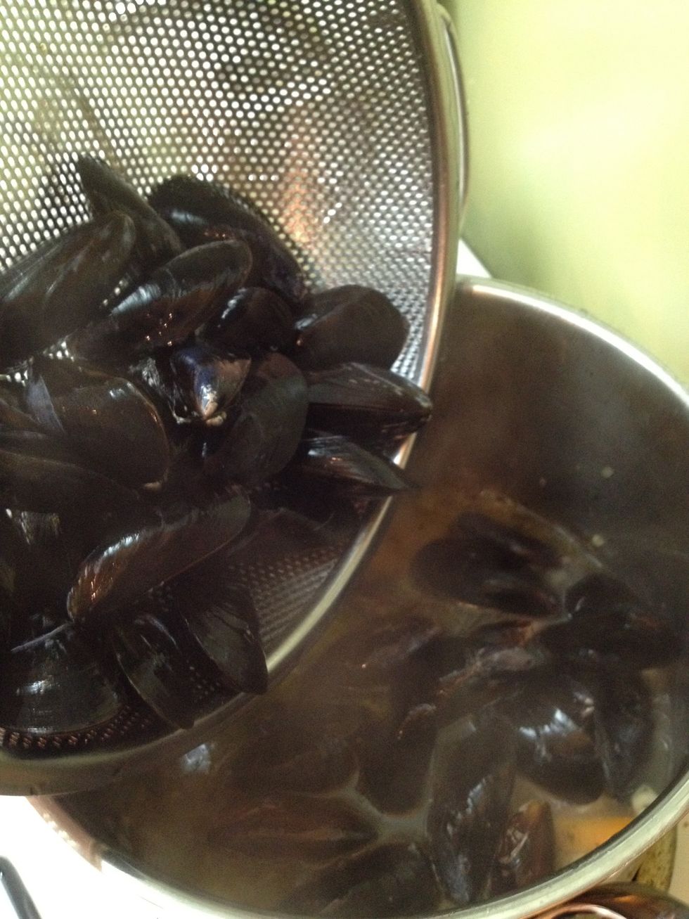 When liquid is boiling, add mussels to pot.