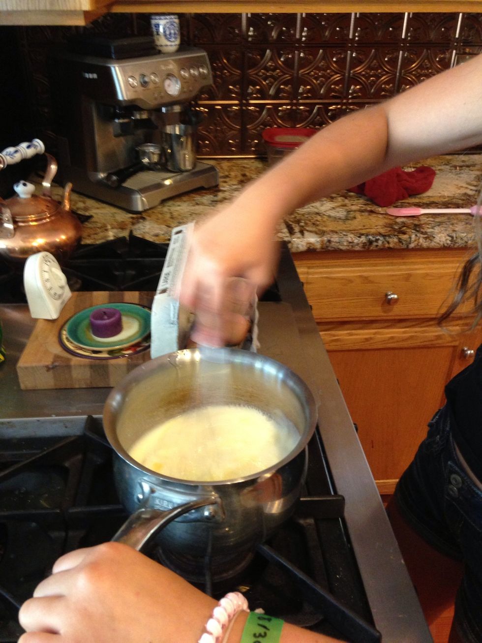 When milk mixture lowers in temperature, crack an egg in and begin whisking. Don't allow it to settle inside, or the egg will begin to cook.