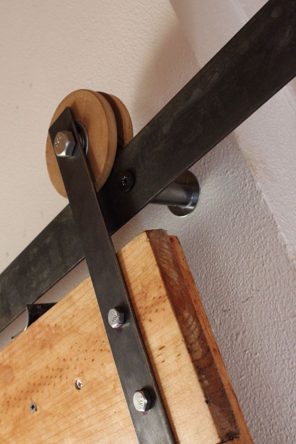 When placing the support bolts on your main track, be sure to allow enough room for the wheel to pass and not hit the steel connected to the wall. Also consider the screw on the front of track.