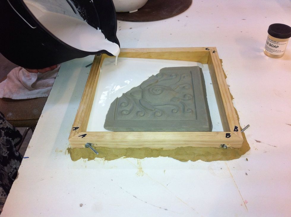 When plaster thickens to heavy cream feel slowly pour into frame