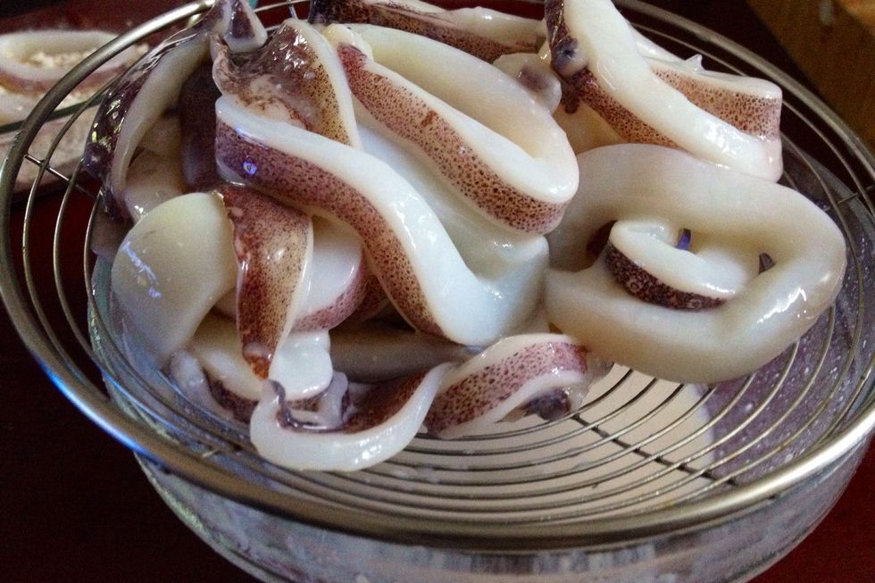 When ready to cook, while oil is heating, use a wire-mesh skimmer to lift about half of squid pieces from buttermilk, allowing excess buttermilk to drip back into bowl.