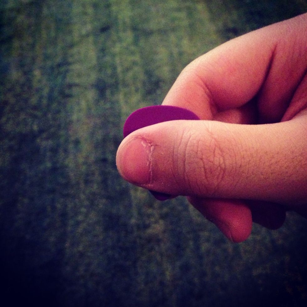 When ready to do a pinch harmonic , bring your thumb close to the tip of the pick , as shown above