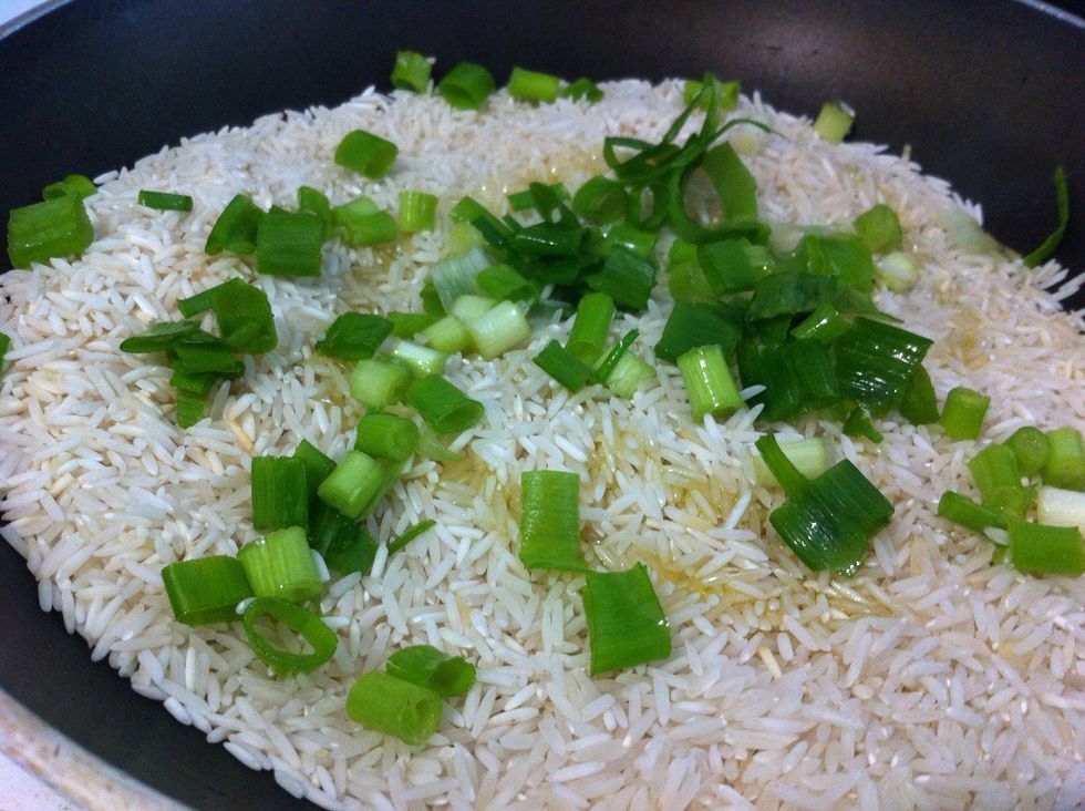 When rice is browned add scallions, olive oil and water to cover rice (at high heat)