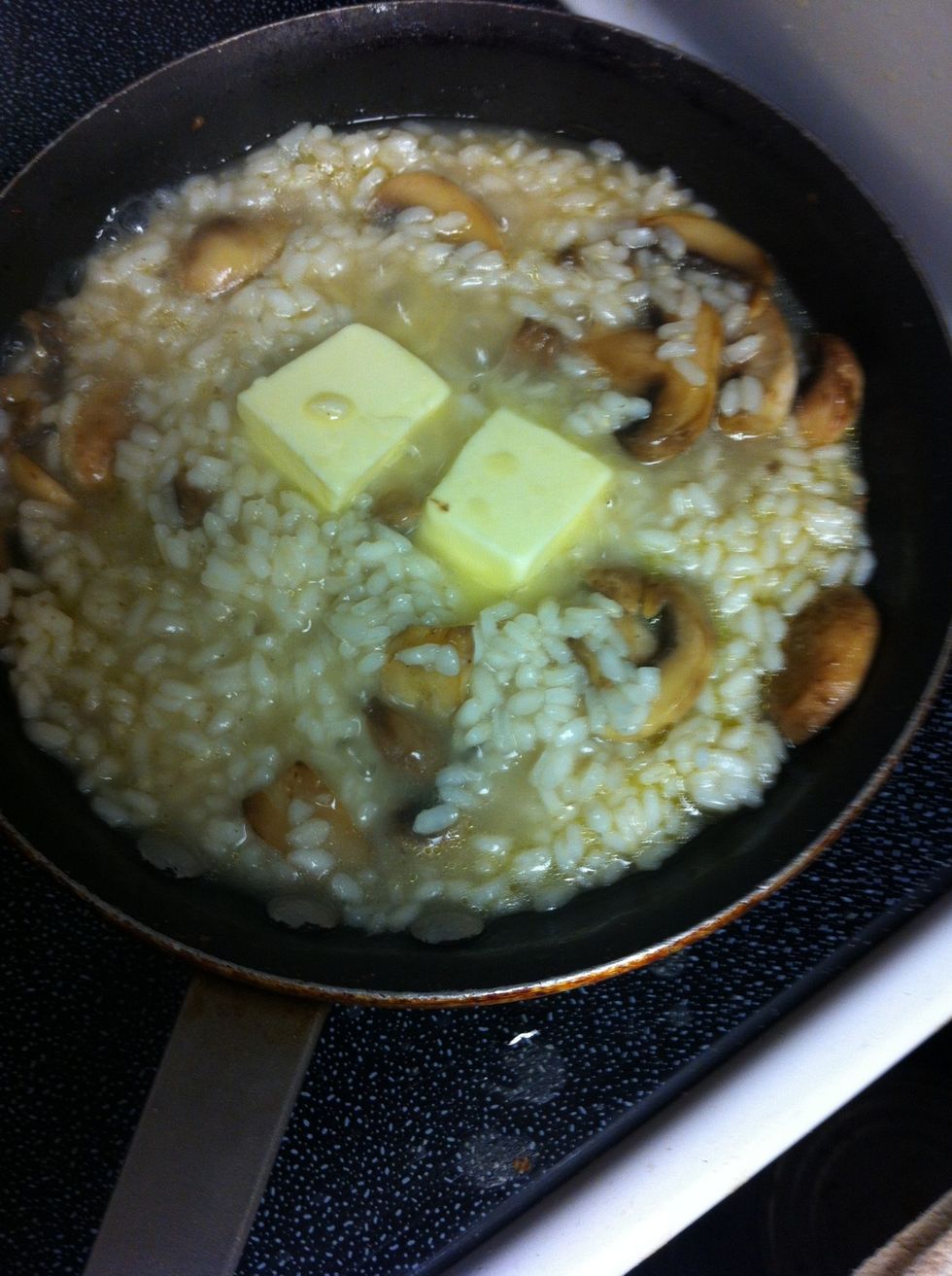 When rice softens, add butter to mixture.