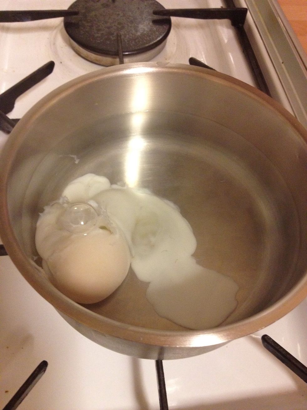 When the 20 seconds is up, gently crack the egg into the pan of boiling water. Leave on simmer.