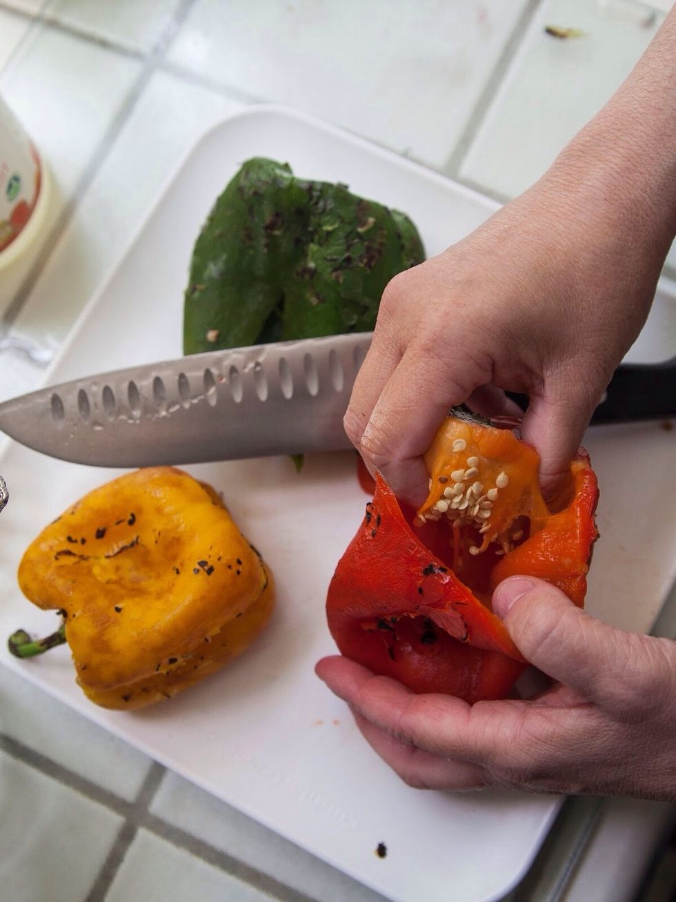 When the blackened skin is gone, pat the pepper dry and seed it.