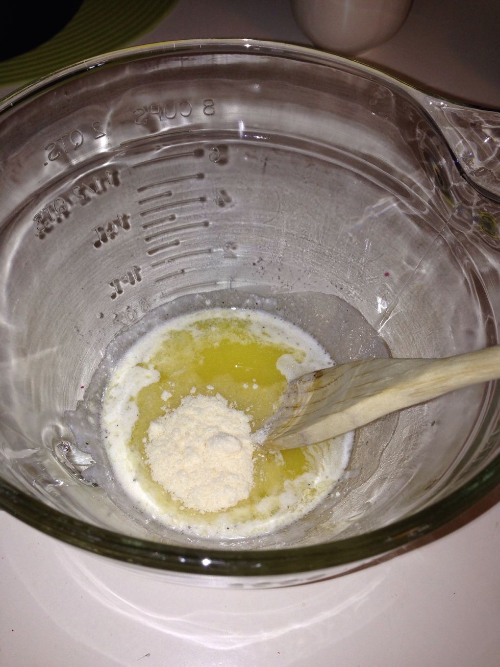 When the butter is fully melted pour the mixture into a bowl and shake in 1 tablespoon of Parmesan cheese. Stir until mixed then set aside.