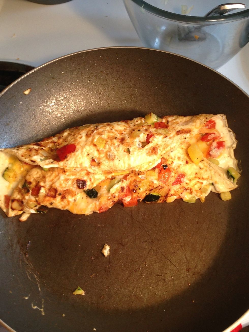 When the cheese starts to melt, use a spatula to fold the two sides over each other.