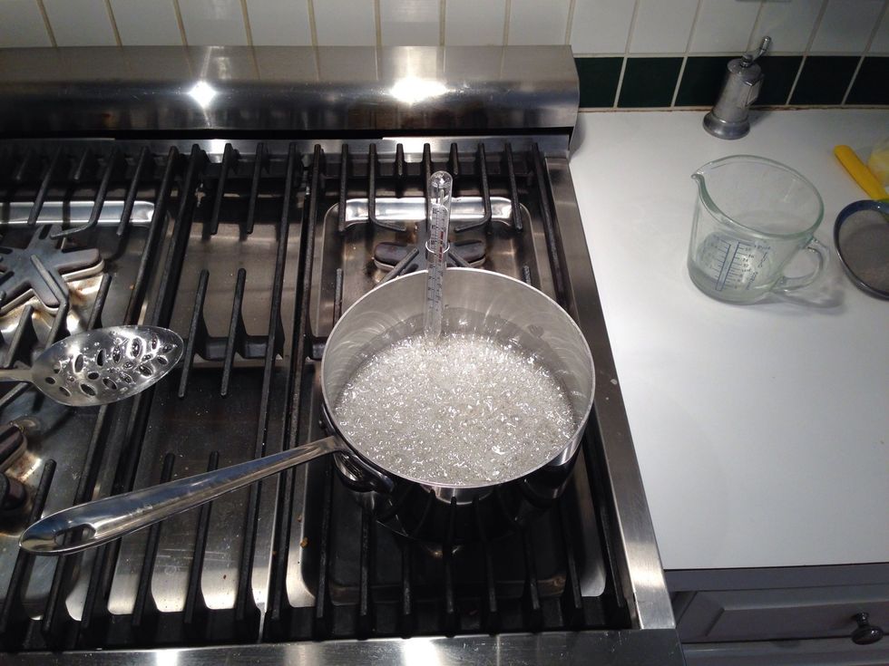 When the chemicals have dissolved, stop stirring and let it boil to desired temp. It's a good idea to put the thermometer on when the pan isn't already hot and full of boiling goo, but it's up to you.