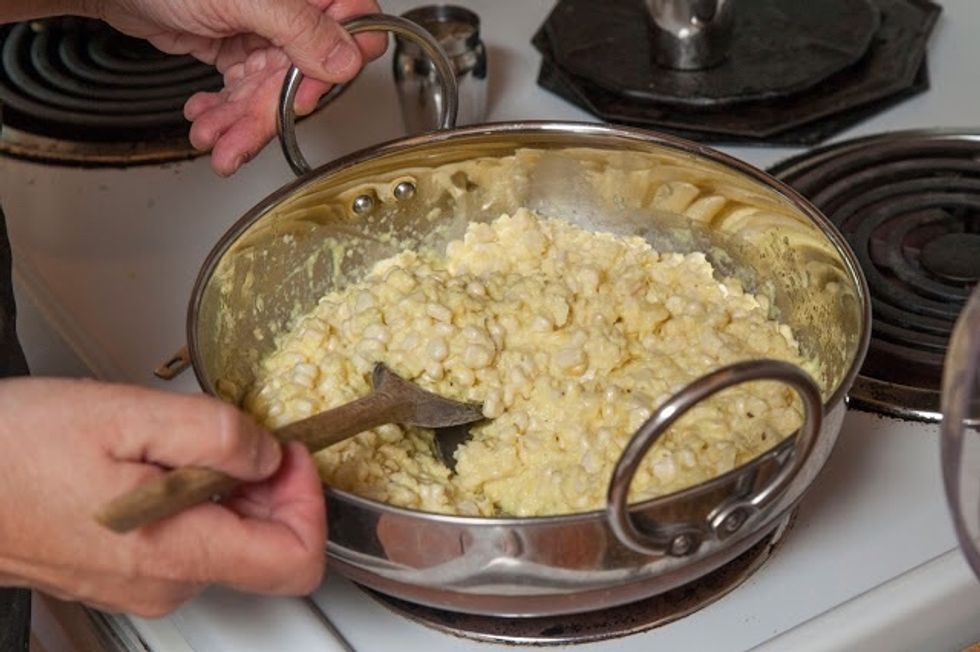 When the cumin seeds start to sizzle and turn color, add in the corn mixture and the turmeric.Mix it together well.