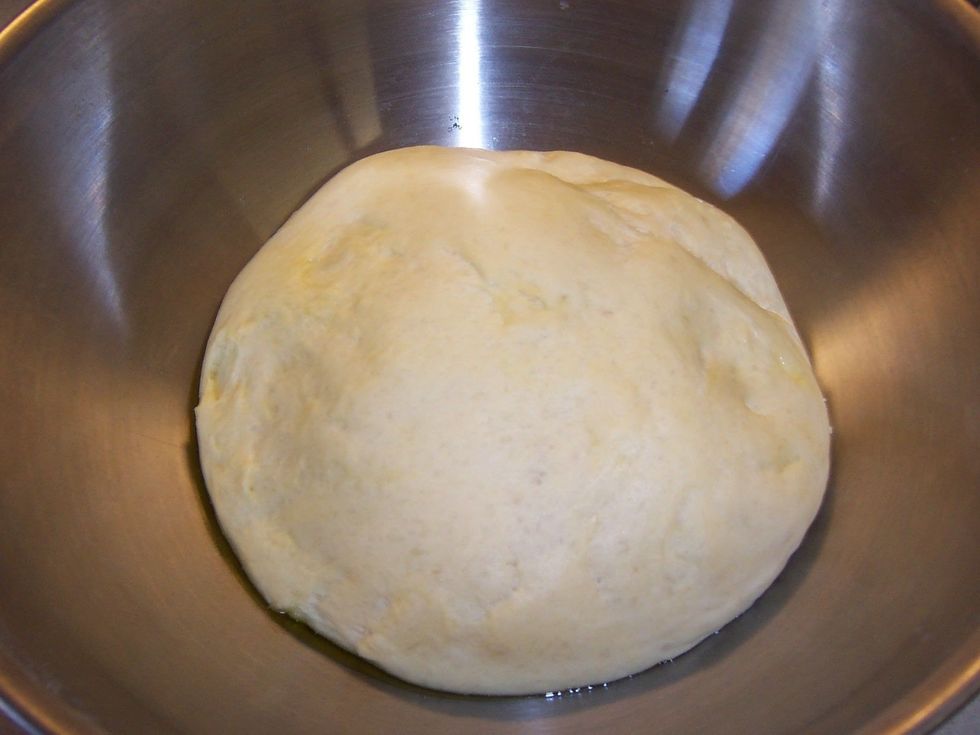 When the dough has doubled, punch it down and divide it into two parts.