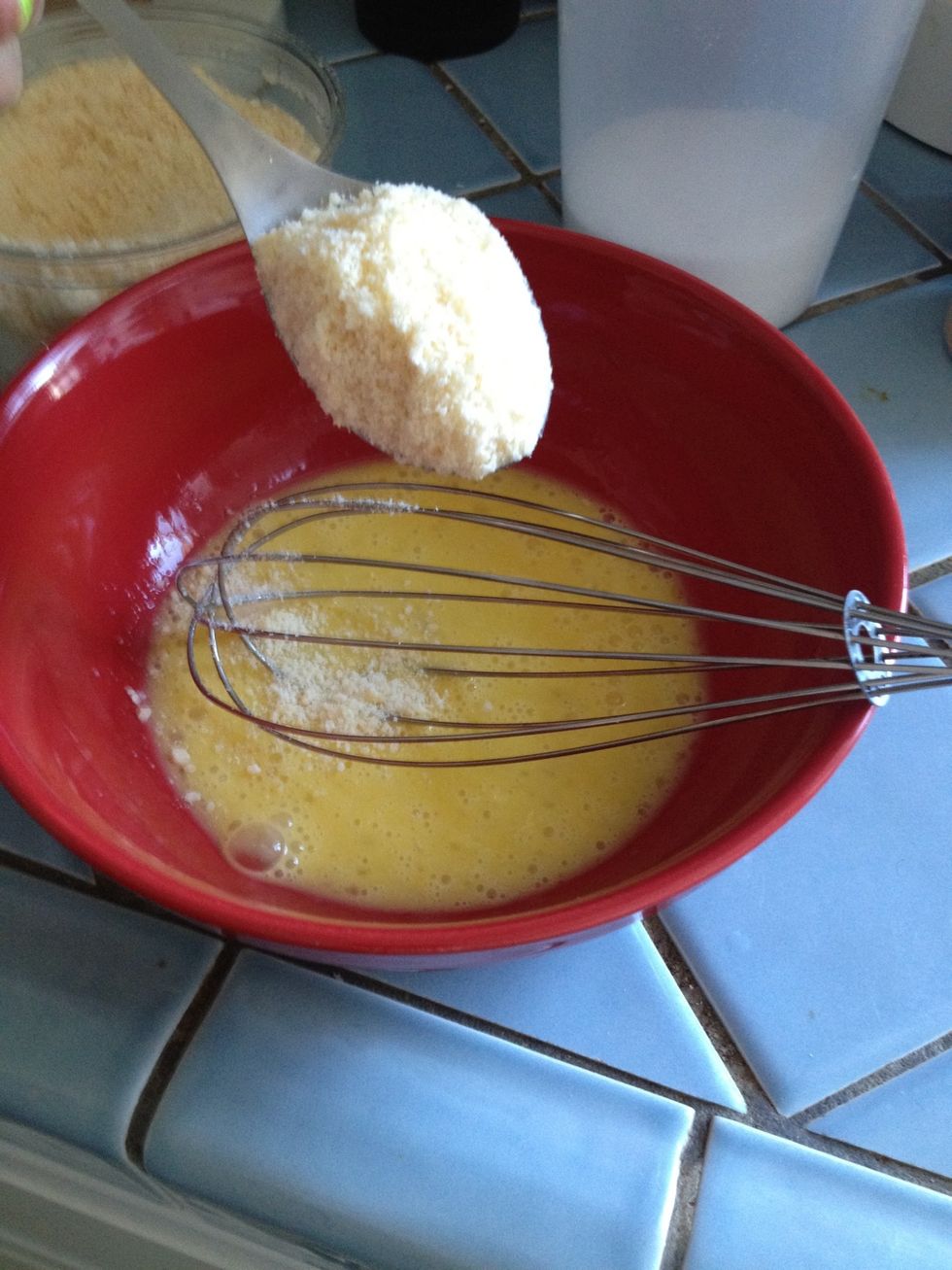 When the egg is fully beaten, begin to add the Parmesan cheese by the spoonful. Stir after each spoonful until you get get a thick consistency. Like a paste.
