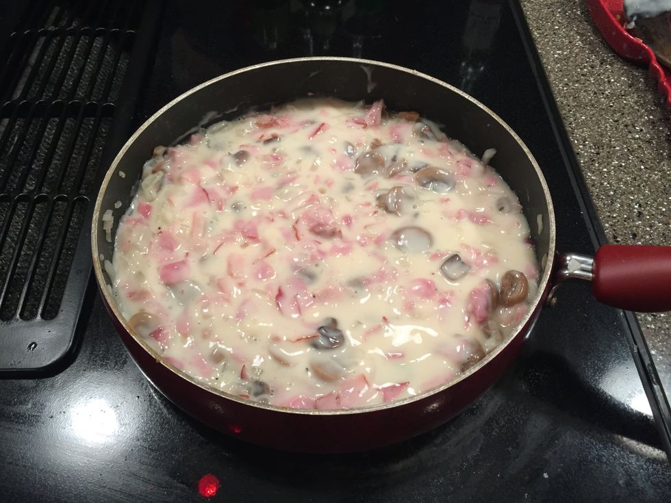 When the five minutes is up add the jar of alfredo sauce to the ham, mushrooms, and onion and let it cook for about 5 minutes or until the alfredo is bubbling.