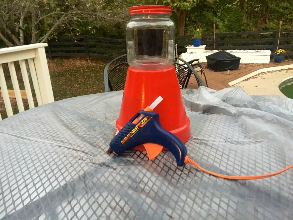 When the flower pot is dried get the jar and hot glue it to the pot.